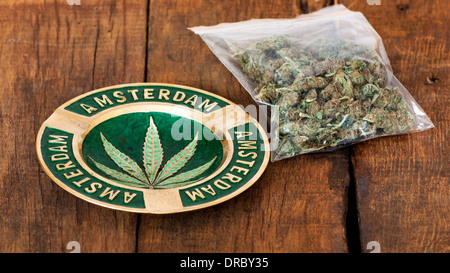 Aschenbecher mit Amsterdam Zeichen und eine große Plastiktüte von Unkraut oder Marihuana auf hölzernen Hintergrund Stockfoto