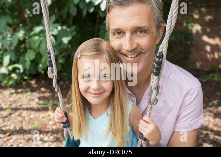 Vater drängen Tochter auf Schaukel Stockfoto