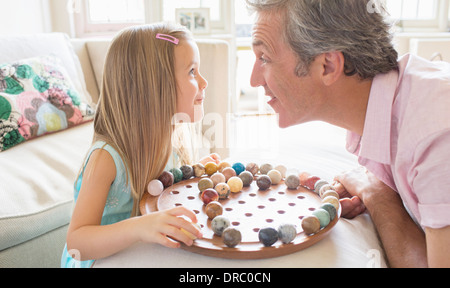 Vater und Tochter spielen Chinese checkers Stockfoto