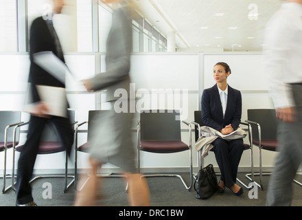 Geschäftsfrau im geschäftigen Wartebereich sitzen Stockfoto