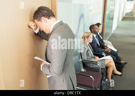Geschäftsmann, stützte sich auf Bürotür Stockfoto