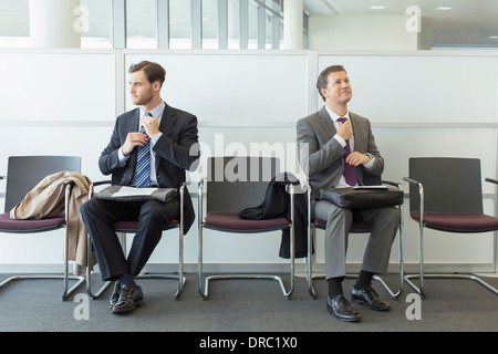 Geschäftsleute, die Anpassung der Bindungen im Wartebereich Stockfoto