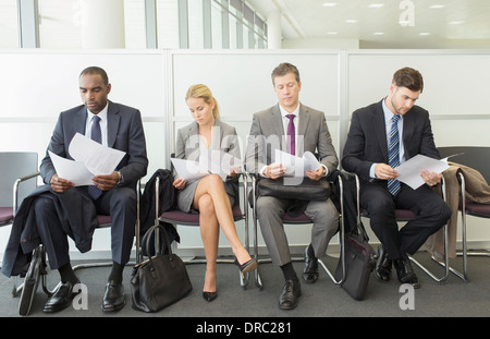 Geschäftsleute, die Lesung im Wartebereich Stockfoto