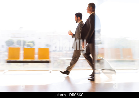 Geschäftsleute, die zu Fuß in Flughafen-Korridor Stockfoto