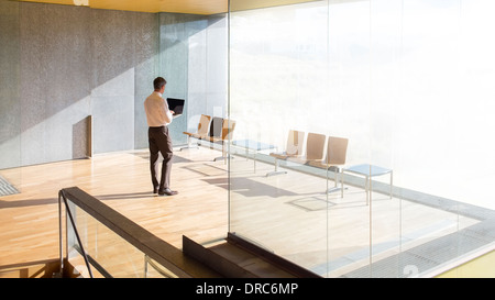 Geschäftsmann mit Laptop im Büro lobby Stockfoto