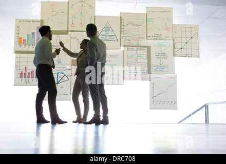 Geschäftsleute, die Diskussion über Diagramme und Grafiken hängen im Büro Stockfoto