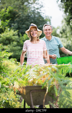 Älteres Paar mit Schubkarre und Schaufel im Garten Stockfoto