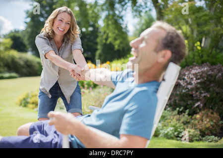 Frau Freund aus Stuhl im Garten ziehen Stockfoto