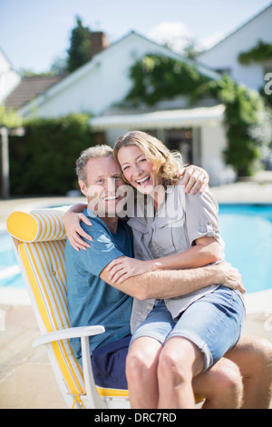 Paar im Liegestuhl am Pool sitzen Stockfoto