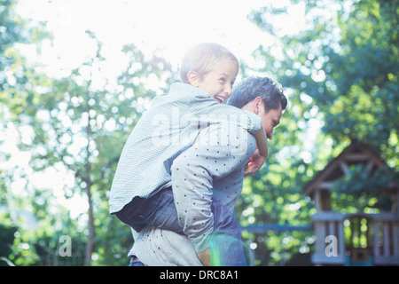 Vater mit Sohn Huckepack im freien Stockfoto