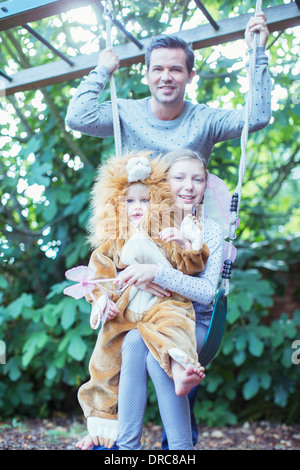 Vater und Kinder spielen gemeinsam auf Schaukel Stockfoto