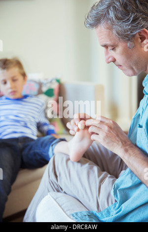 Vater Bandagierung Sohn Zehe Stockfoto