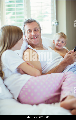 Vater und Kinder entspannend auf Bett Stockfoto