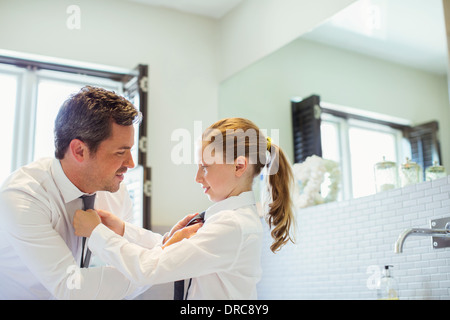 Vater und Tochter gegenseitig ihre Krawatten binden Stockfoto