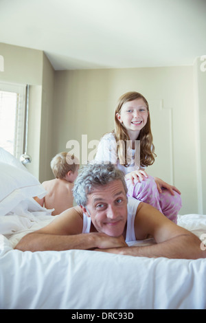 Vater, spielen mit Kindern auf Bett Stockfoto