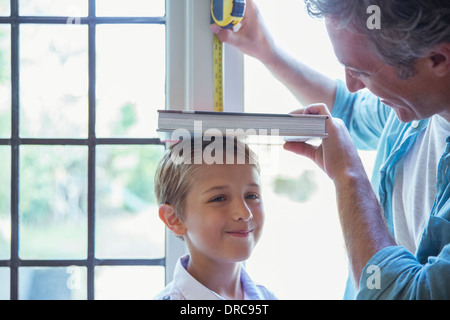 Vater Mess Sohn Höhe an Wand Stockfoto