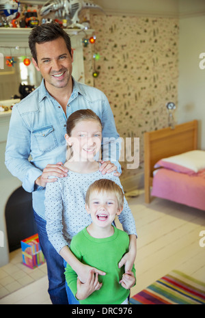 Vater und Kinder Lächeln im Schlafzimmer Stockfoto