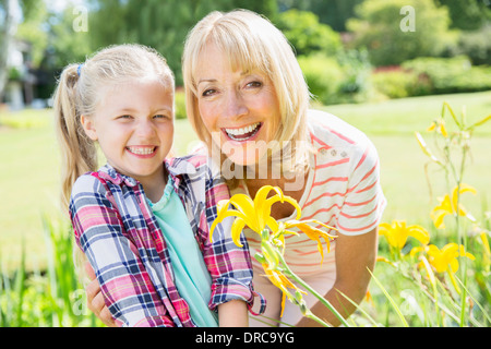 Großmutter und Enkelin lächelnd in Garten Stockfoto