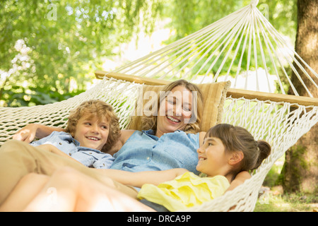 Mutter und Kinder gemeinsam in der Hängematte entspannen Stockfoto