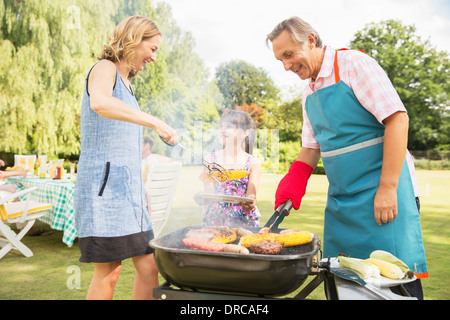 Generationsübergreifende Familie stehen am Grill im Garten Stockfoto