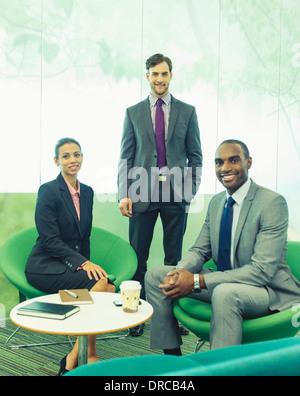 Geschäftsleute, die lächelnd im Büro Stockfoto
