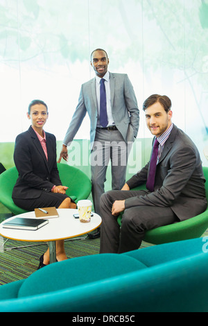 Geschäftsleute, die lächelnd im Büro Stockfoto