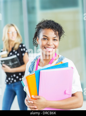 Lächelnde Studentin mit Ordnern Stockfoto