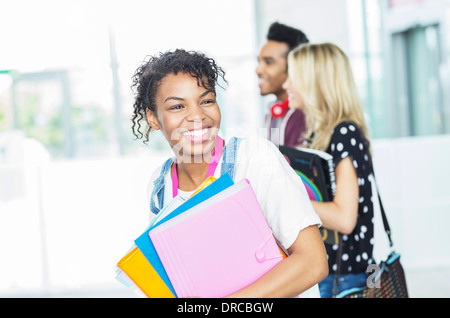 Lächelnde Studentin mit Ordnern Stockfoto