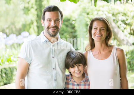 Familie lächelnd zusammen im freien Stockfoto