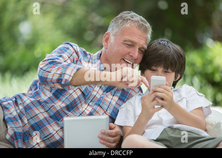 Großvater und Enkel, die mit digitalen Tablet und Handy Stockfoto