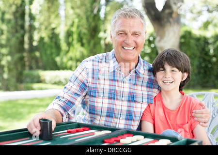 Großvater und Enkel spielen Backgammon auf Terrasse Stockfoto