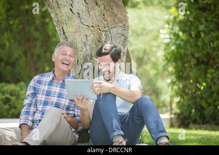 Vater und Sohn mit digitalen Tablet im freien Stockfoto