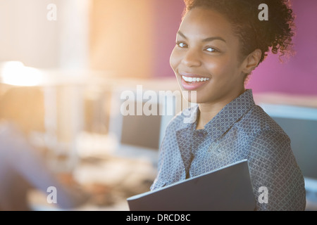 Geschäftsfrau, die lächelnd im Büro Stockfoto