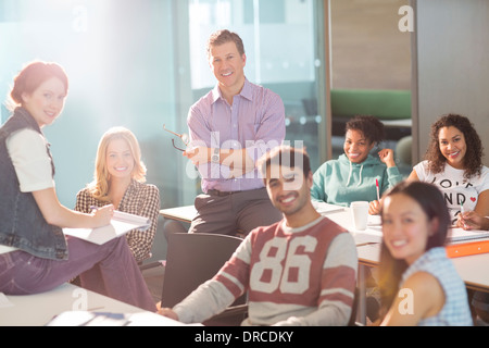 Professor und Studenten, die lächelnd im Klassenzimmer Stockfoto