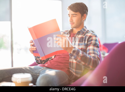 Schüler lesen Lehrbuch im café Stockfoto