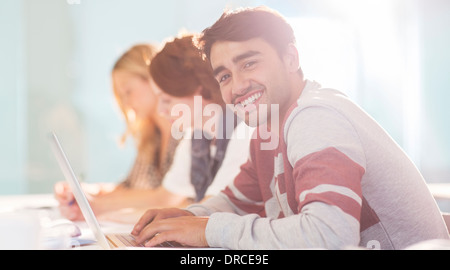 Uni-Student lächelnd im Klassenzimmer Stockfoto