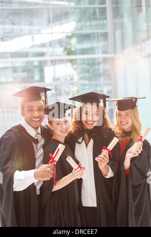 Lächelnd hält Diplome Absolventen Stockfoto