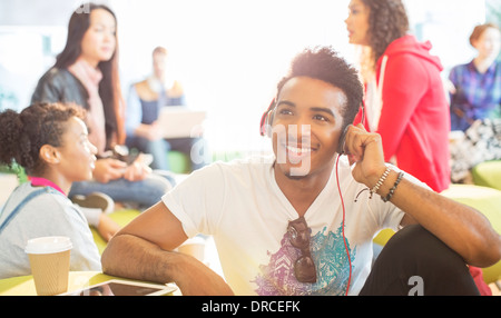 Uni-Student Kopfhörer anhören, in der lounge Stockfoto