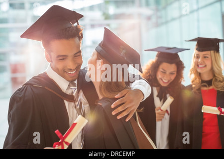 Absolventinnen und Absolventen umarmt Stockfoto