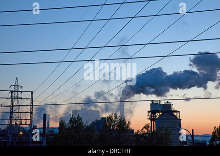 Silhouette der Rauch ausstoßen von Fabrik bei Sonnenaufgang Stockfoto
