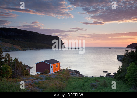 Bootshaus mit Blick auf die ruhige Bucht bei Sonnenaufgang Stockfoto