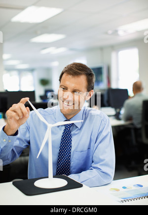 Geschäftsmann, Prüfung Spielzeug Windrad im Büro Stockfoto