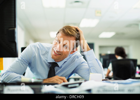 Geschäftsmann, Schielen auf Schreibtisch im Büro Stockfoto