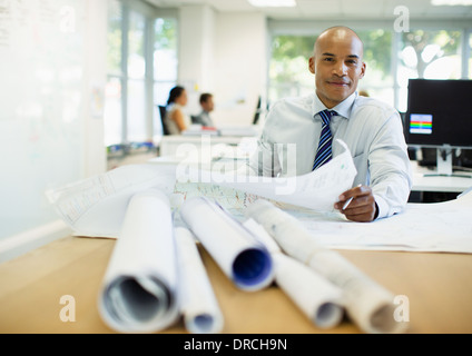 Geschäftsmann, Prüfung der Baupläne im Büro Stockfoto