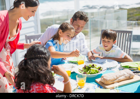 Familie beim Mittagessen am Tisch auf der sonnigen Terrasse Stockfoto