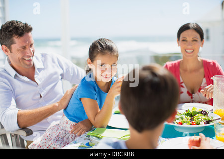 Familie beim Mittagessen am Tisch auf der sonnigen Terrasse Stockfoto