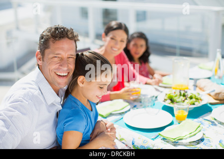 Familie beim Mittagessen am Tisch auf der sonnigen Terrasse Stockfoto