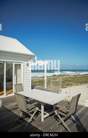 Tisch und Stühle auf der Terrasse mit Blick auf Strand Stockfoto