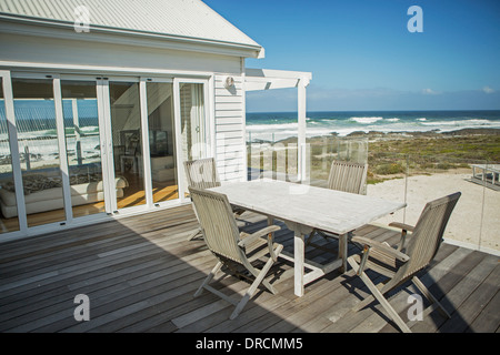 Tisch und Stühle auf dem Balkon mit Blick auf Strand Stockfoto