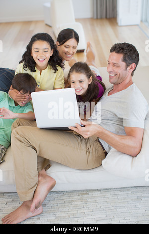 Familie mit Laptop auf dem Sofa im Wohnzimmer Stockfoto